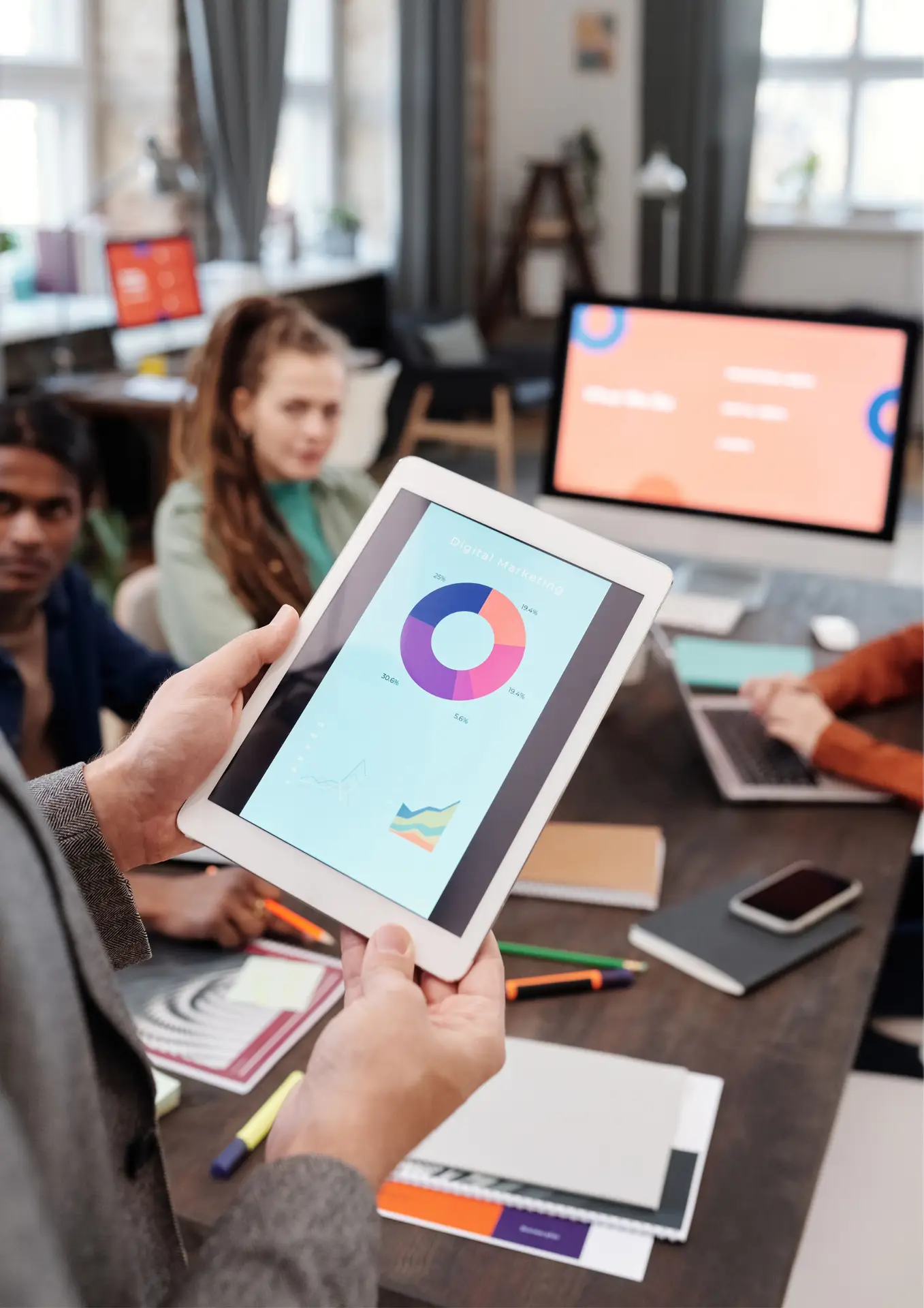 a person holding a tablet with a pie chart on it