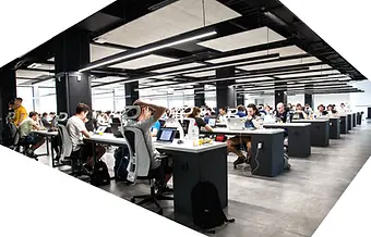 a group of people sitting at desks in a room